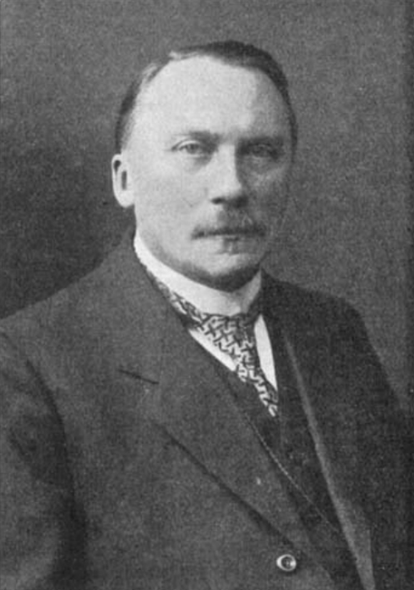Portrait of Ewald Rübsaamen in a suit and patterned tie